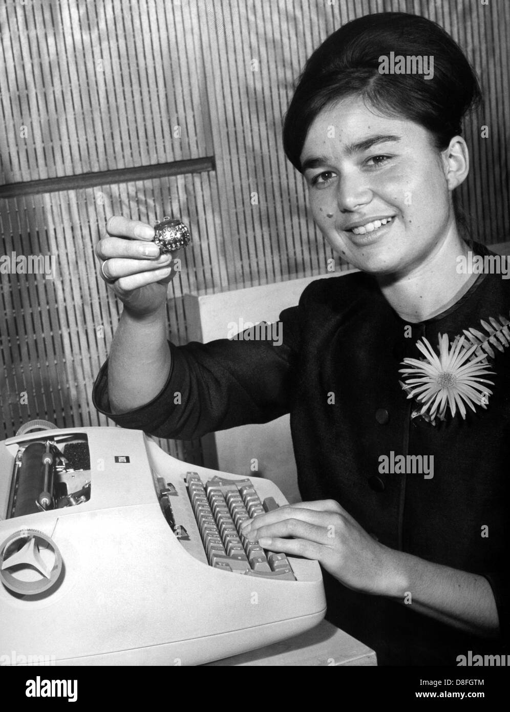 Mme Mayer, Baden-Wurttembergian Champion de typage, vérifie la nouvelle machine à écrire IBM savamment en octobre 1961. Elle a la tête sphérique innovant dans sa main. Banque D'Images