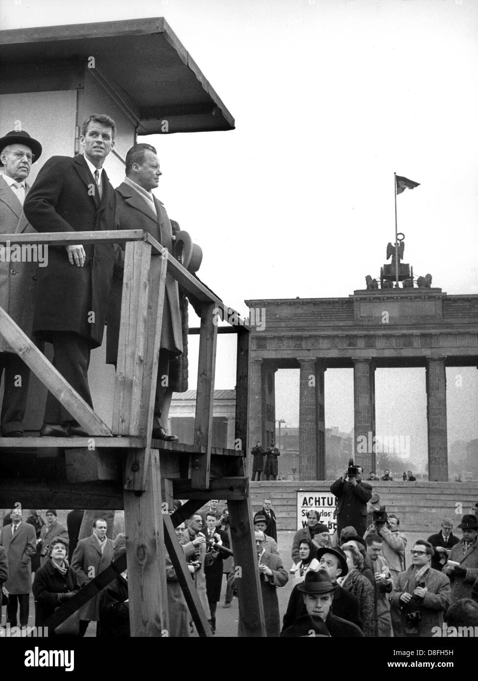 Le secrétaire américain de la justice Robert F. Kennedy (2-L) et maire de Berlin-Ouest Willy Brandt (3-L) Visitez le Mur de Berlin, 23 février 1962. Banque D'Images