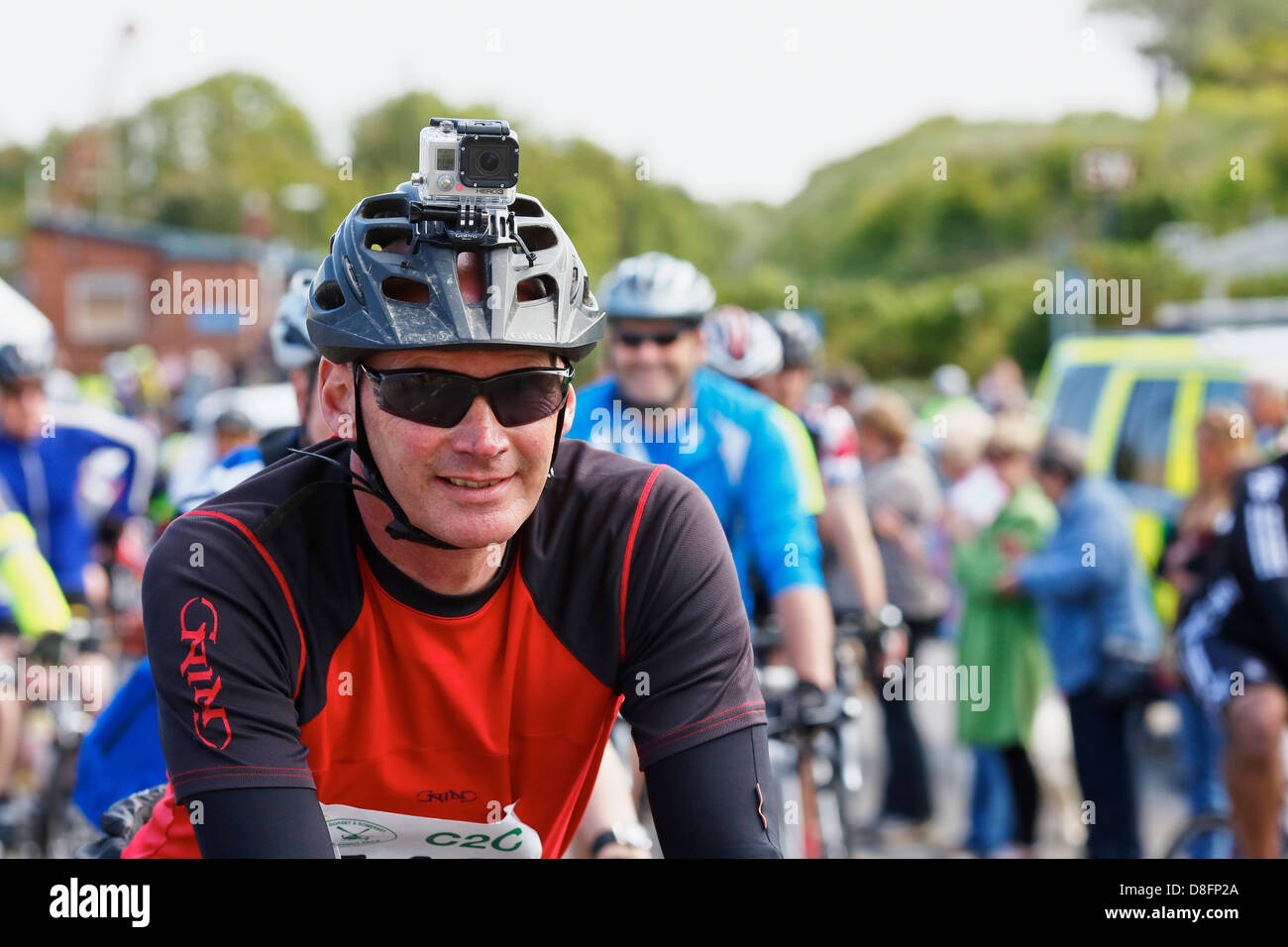 Cycliste avec un casque appareil photo se prépare pour le début de la côte à l'autre défi cycle 2013 de Watchet à Bridport Banque D'Images