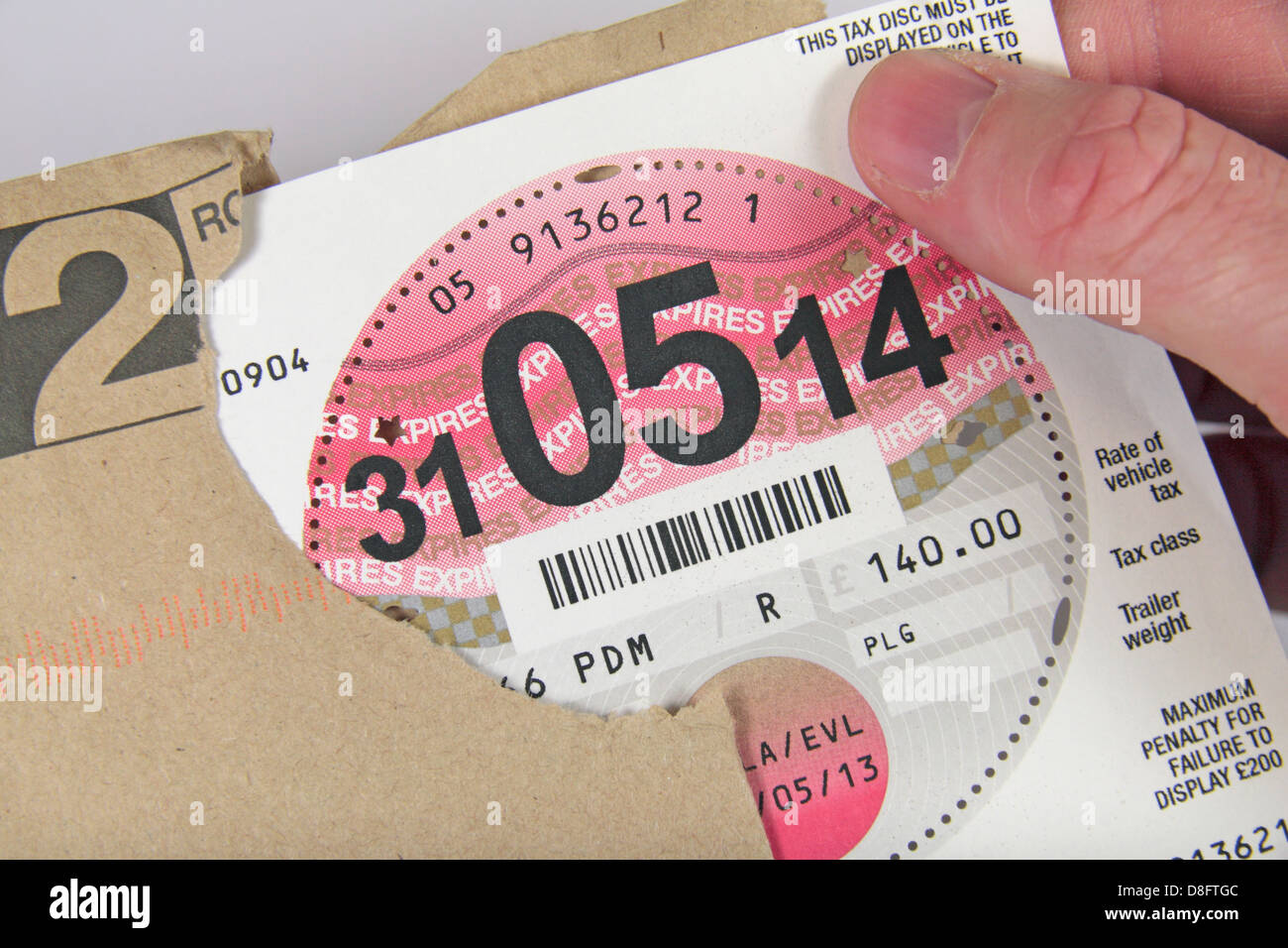 L'ouverture d'une enveloppe contenant une nouvelle UK road/taxe automobile disques (UK voiture). Banque D'Images