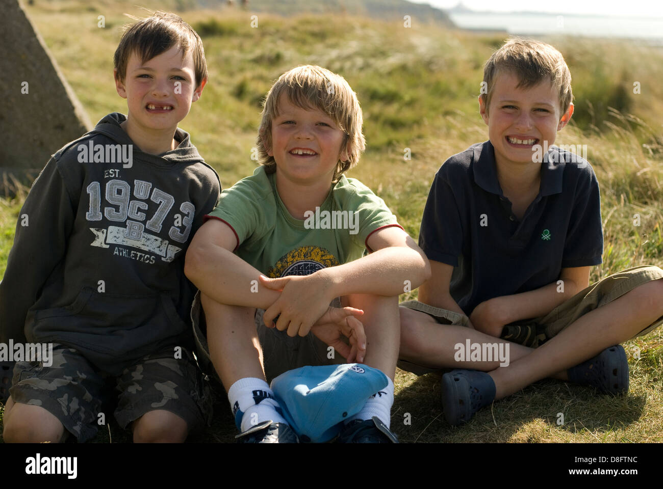 Trois garçons assis Banque D'Images