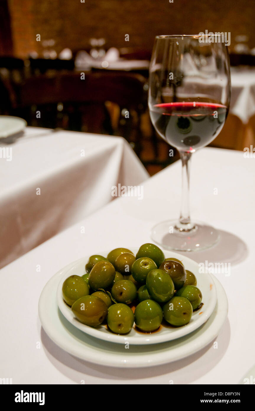 Apéritif espagnol : verre de vin rouge et les olives vertes. Banque D'Images