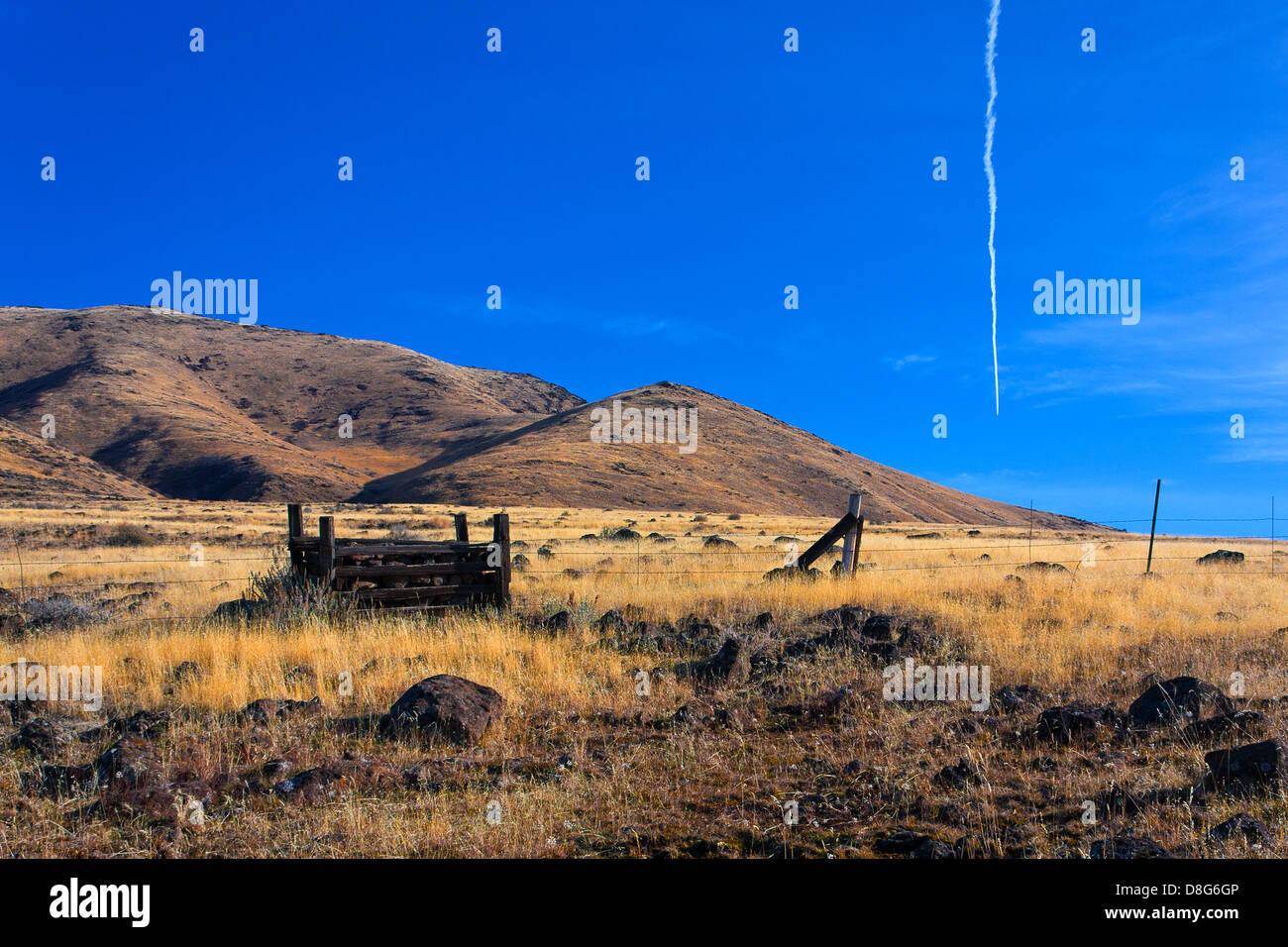 Terrain sec avec des roches et de dépendance en bois contre l'arrière-plan de collines et ciel bleu sur Butte Squaw en Emmett, Idaho Banque D'Images