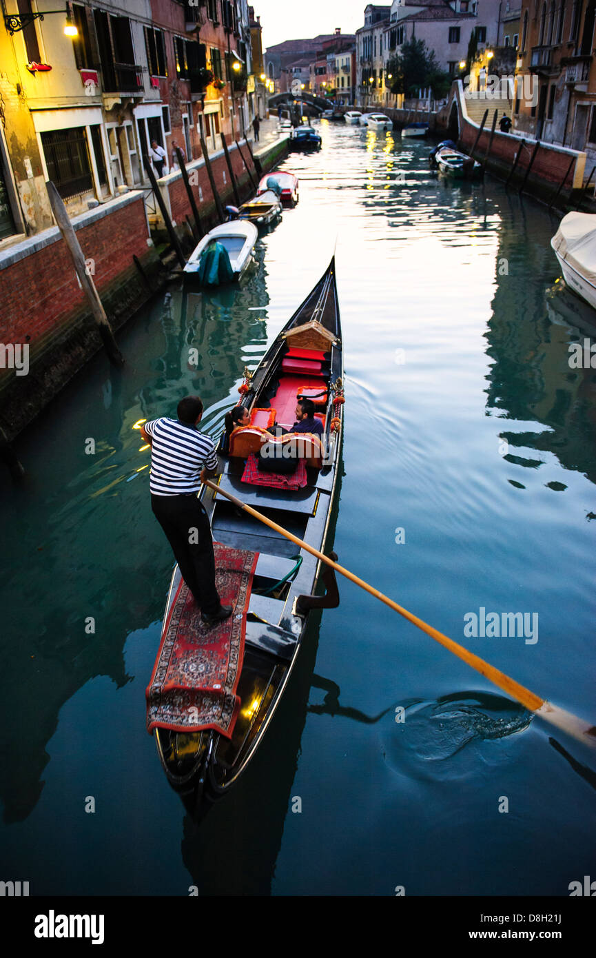 Un couple dans une gondole sur un canal de Venise, Italie. Banque D'Images