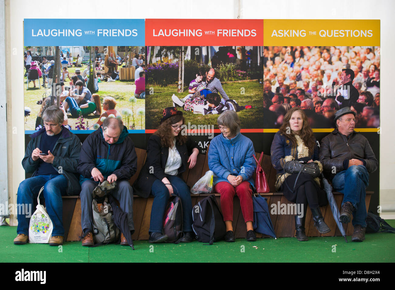 Les visiteurs se détendre sur un banc entre les événements de la Telegraph Hay Festival 2013 Hay-on-Wye Powys Pays de Galles UK Banque D'Images