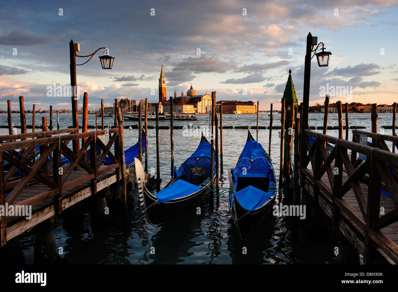 Amarré au bord de l'eau Venise gondoles avec San Giorgio Maggiore en arrière-plan, de l'Italie. Banque D'Images