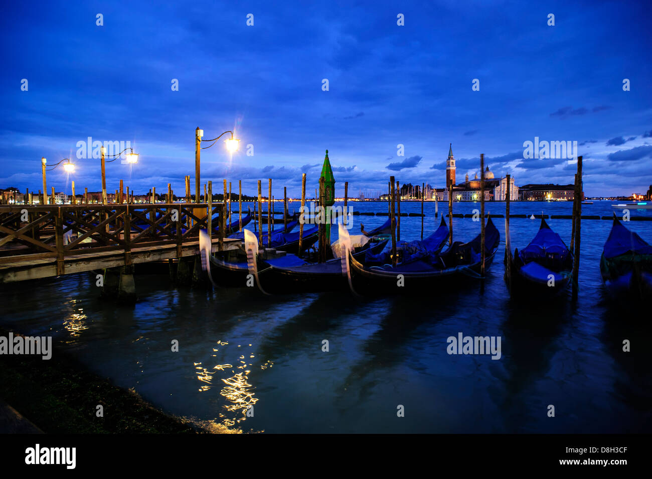 Gondoles de Venise amarrée au bord de l'eau au crépuscule, en Italie. Banque D'Images