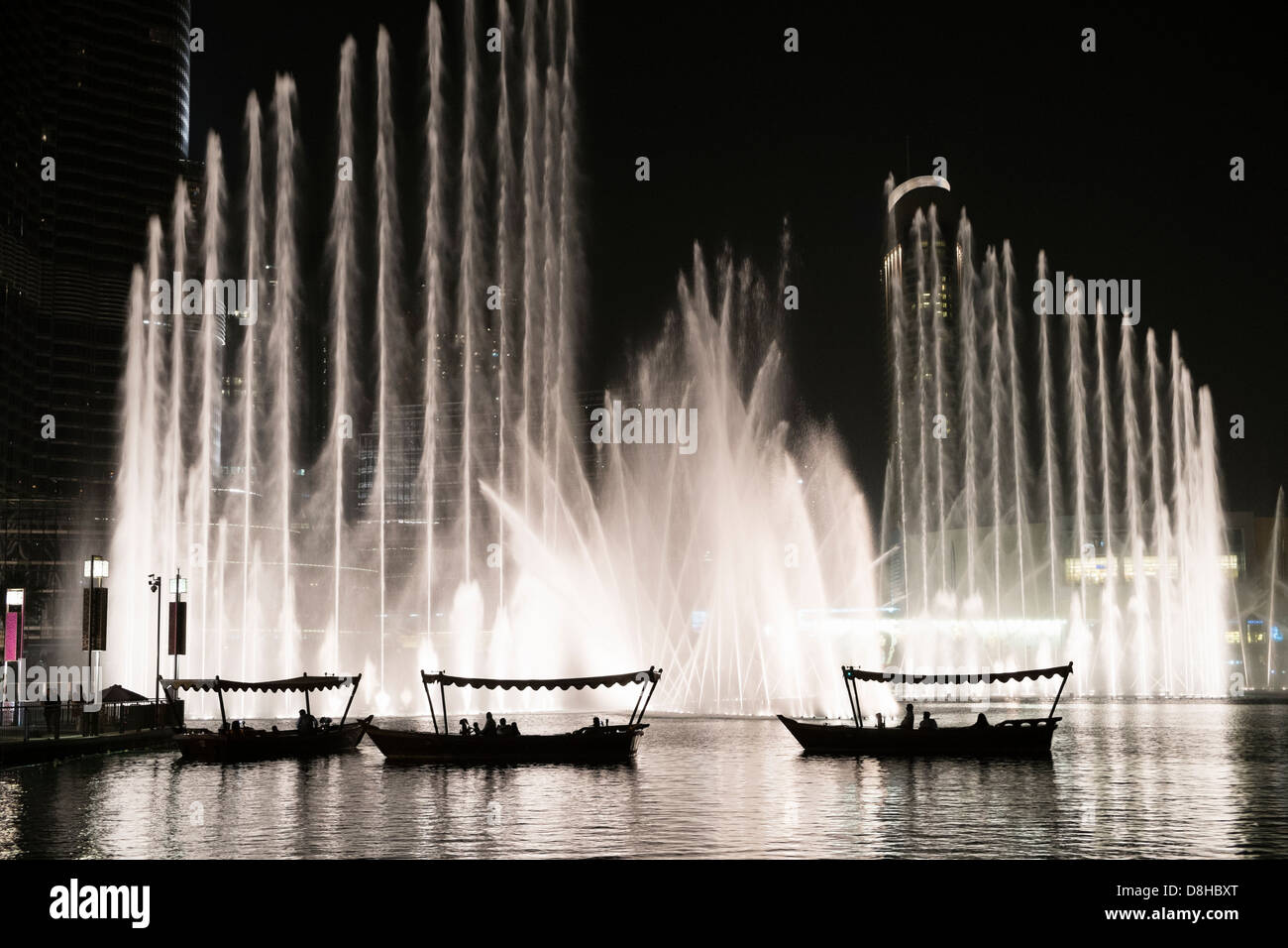 De petites embarcations transportant les touristes à regarder la fontaine de Dubaï au centre commercial de Dubaï en Émirats Arabes Unis Banque D'Images