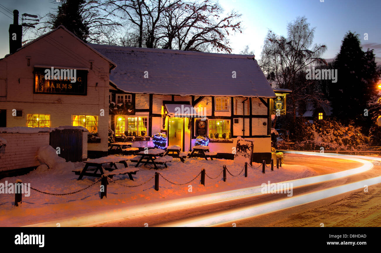 Le bras de Pickerings Pub à Thelwall dans la neige de l'hiver au sud Warrington Cheshire England UK Image Nuit Banque D'Images