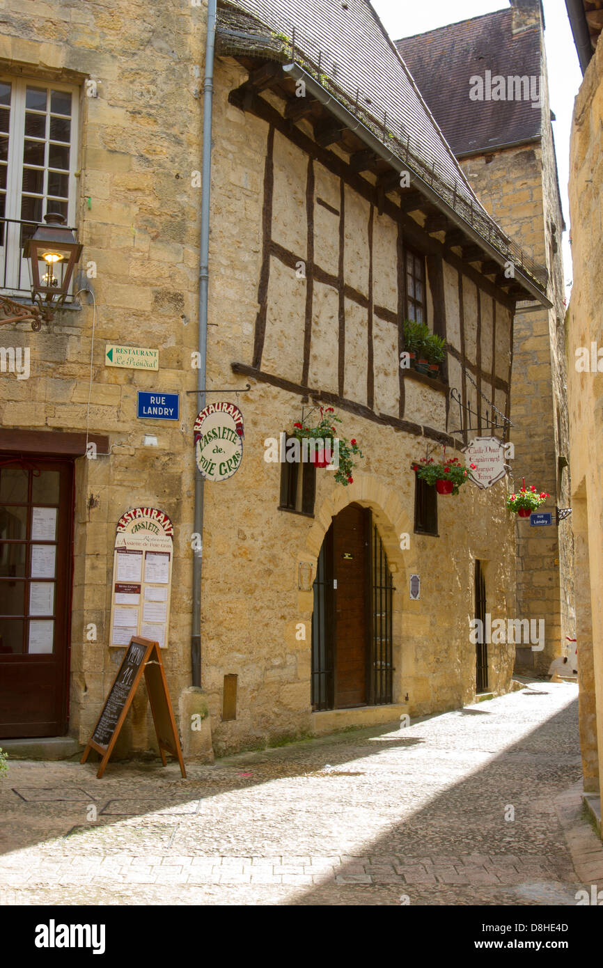 Rue pavées étroites entre les bâtiments en grès médiévale bordée de magasins, dans la charmante ville de Sarlat, Dordogne France Banque D'Images