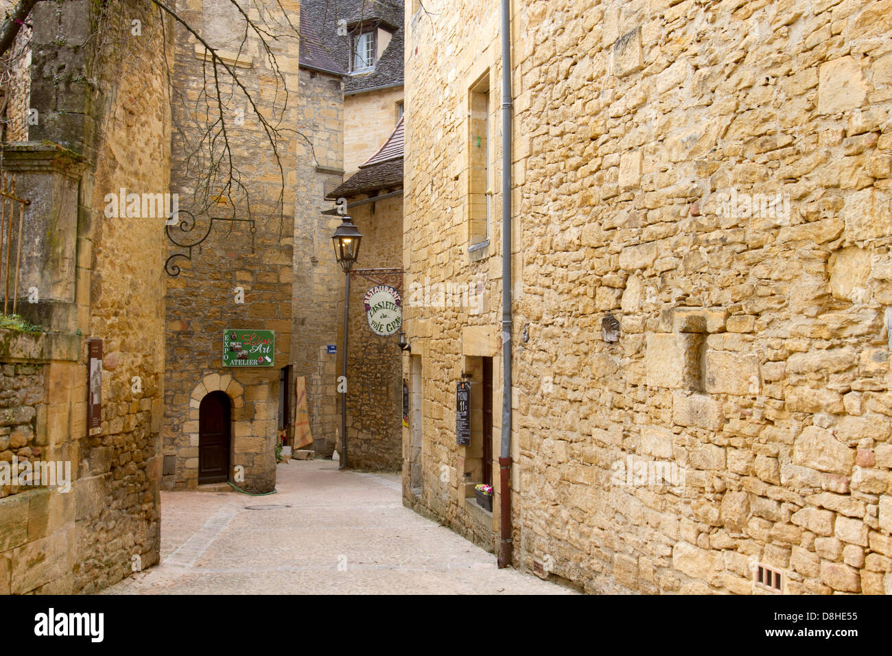Boutiques une étroite rue pavée, entre les bâtiments en grès médiévale dans la charmante ville de Sarlat, Dordogne France Banque D'Images