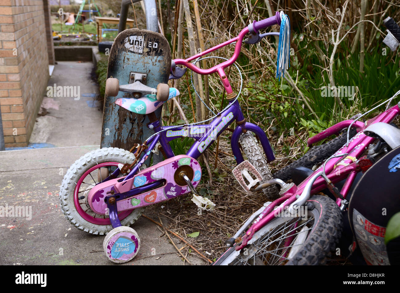 Des vélos pour enfants et du skateboard sur un chemin de jardin, Pays de Galles, Royaume-Uni Banque D'Images