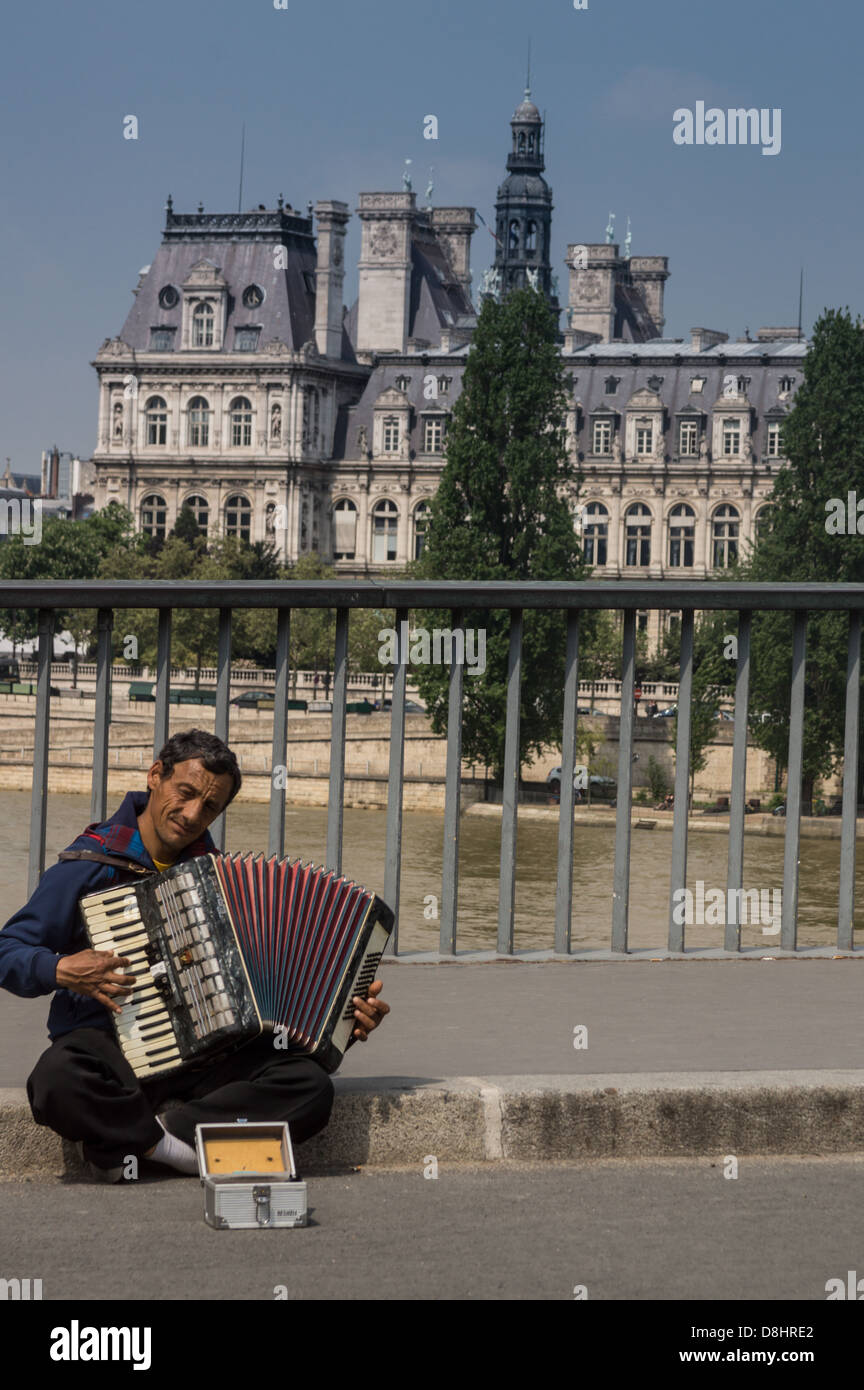 Paris, France. Un homme fait un accordéon sur le pont entre l'Île de la Cité et l'île Saint-Louis. Hôtel de Ville derrière Banque D'Images