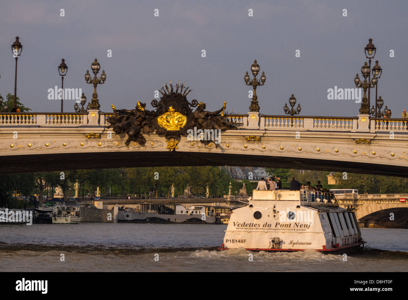 Paris, France. Un bateau de tourisme de la "Vedettes du pont neuf' company navigue sous l'or-orné pont Alexandre III. Banque D'Images