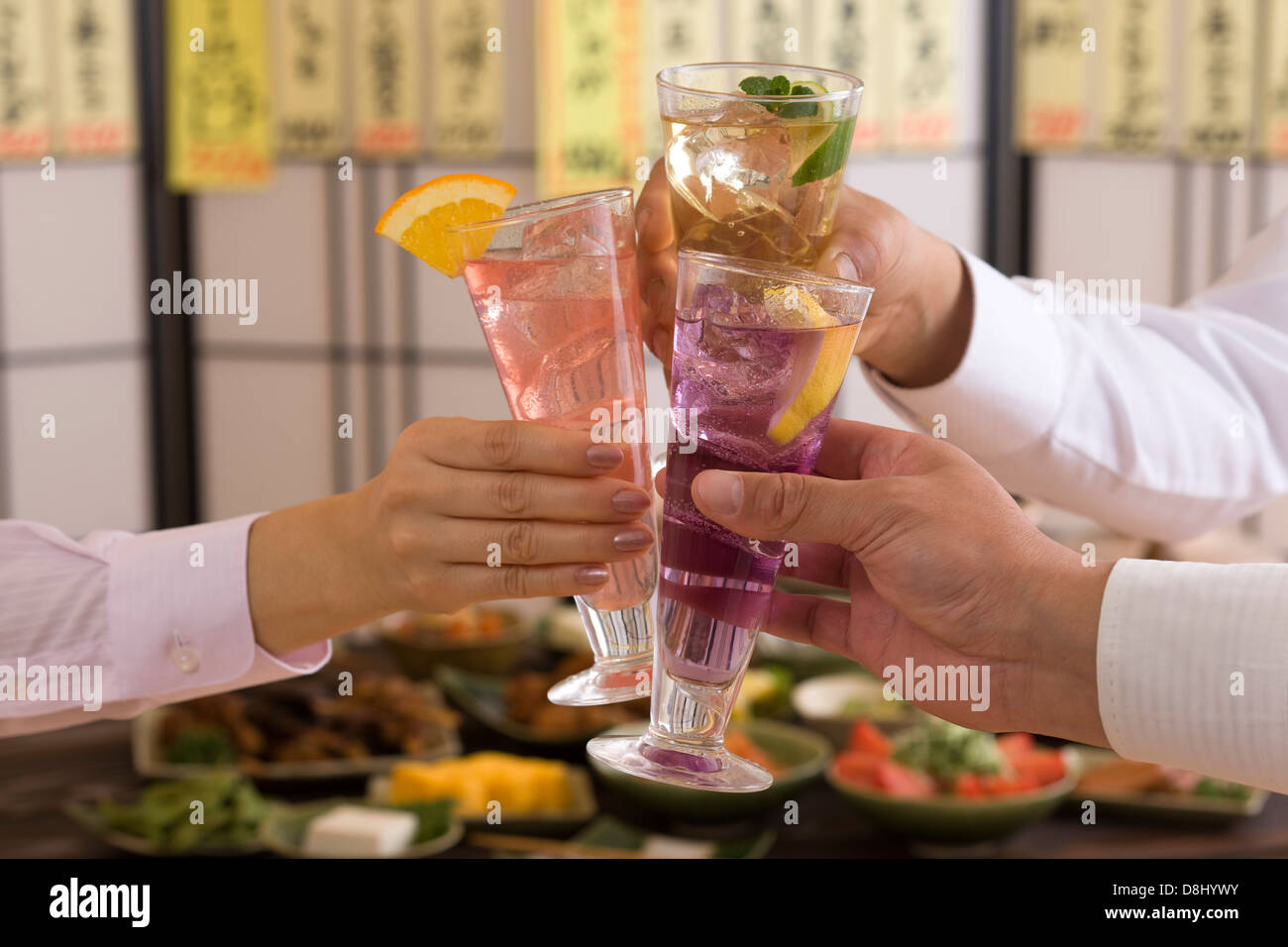 Trois personnes Toasting avec divers cocktails à l'izakaya Banque D'Images