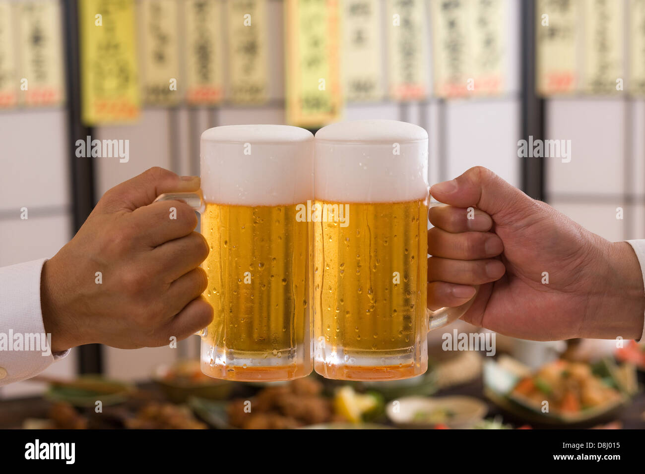 Deux People Toasting with Beer à l'izakaya Banque D'Images