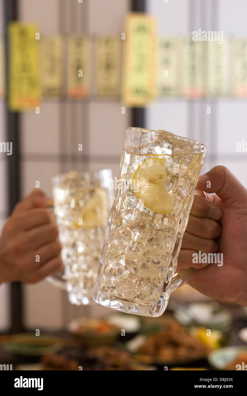 Deux personnes le grillage avec le whisky et soda à l'izakaya Banque D'Images