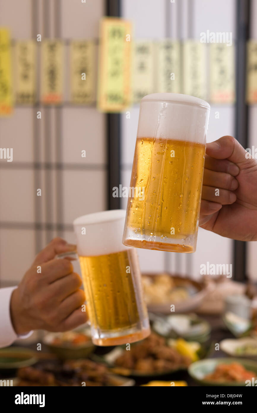 Deux People Toasting with Beer à l'izakaya Banque D'Images