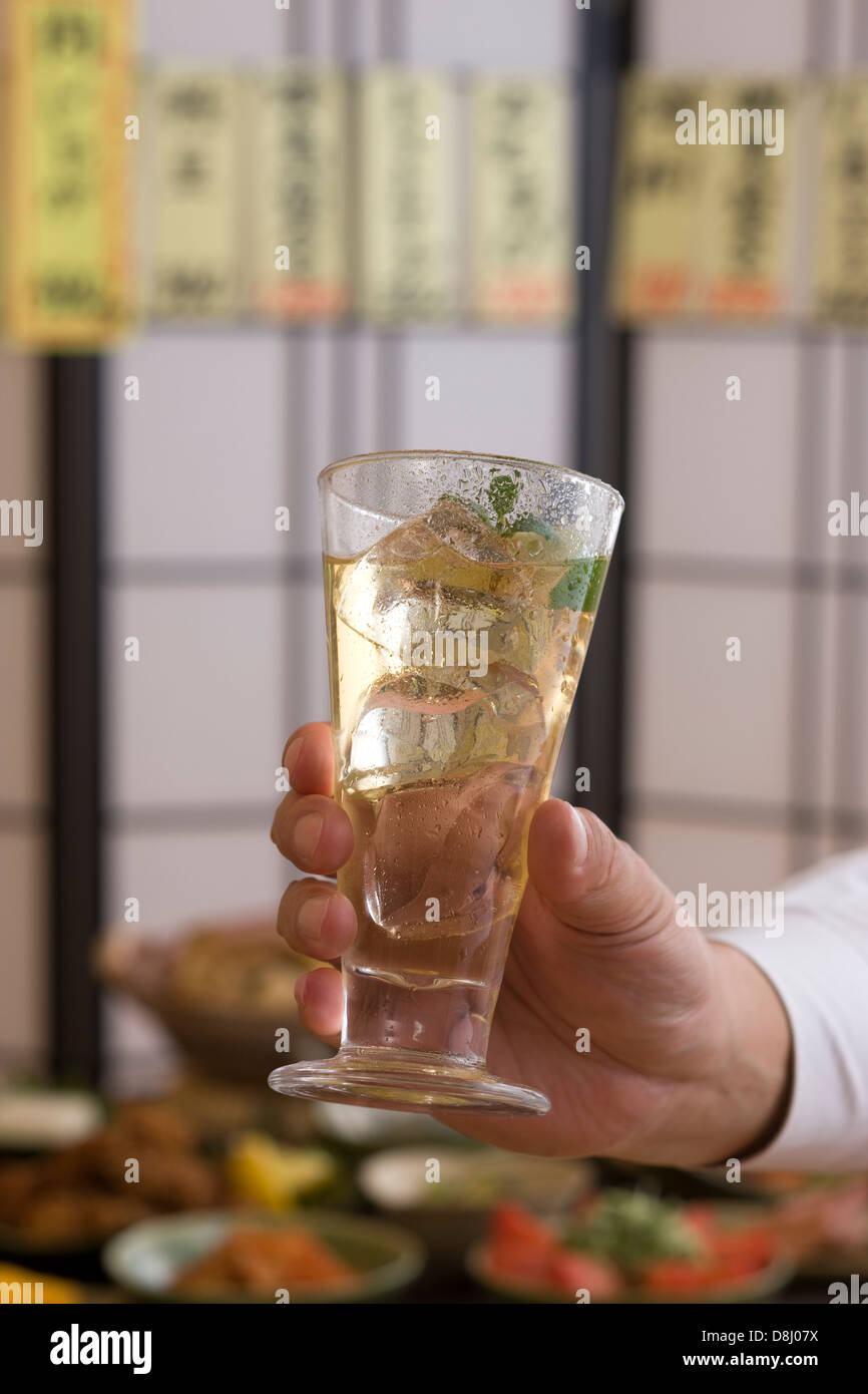 Human Hand Holding verre de cocktail à l'izakaya Banque D'Images
