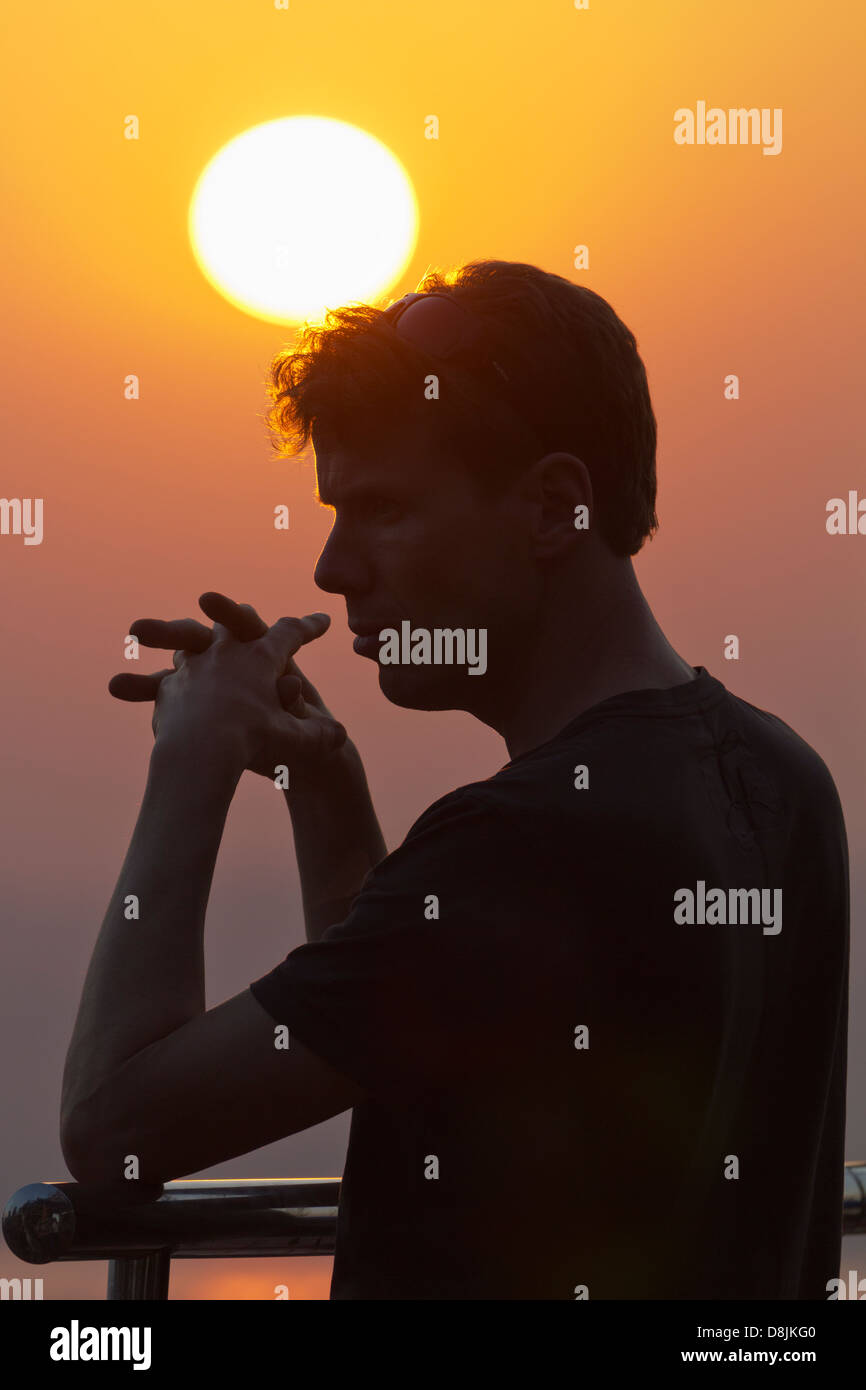 L'homme qui se profile sur Mandalay Hill point d'observation au coucher du soleil, le Myanmar Banque D'Images