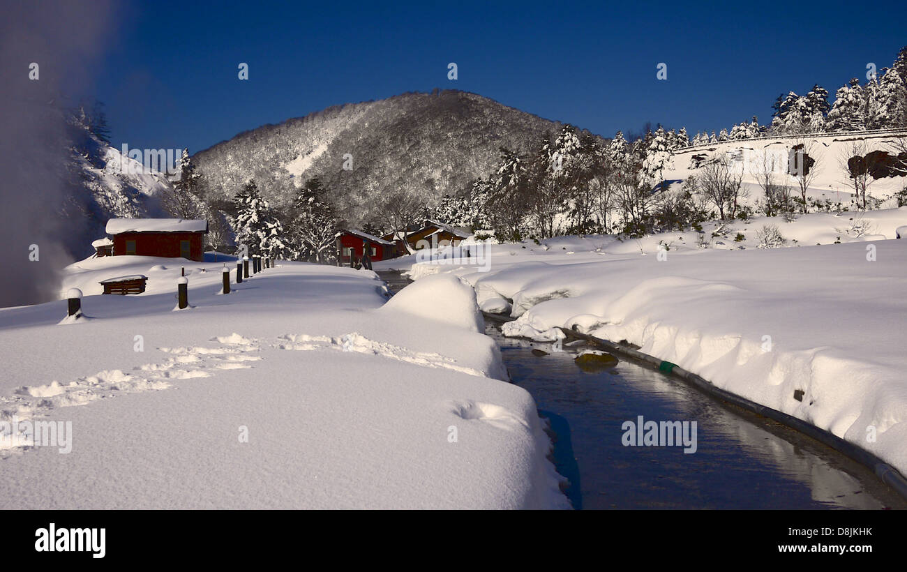 Un écoulement humide piétons traversant un champ de neige épais reliant l'abri de l'Onsen Tamagawa abris et le Ryokan Banque D'Images