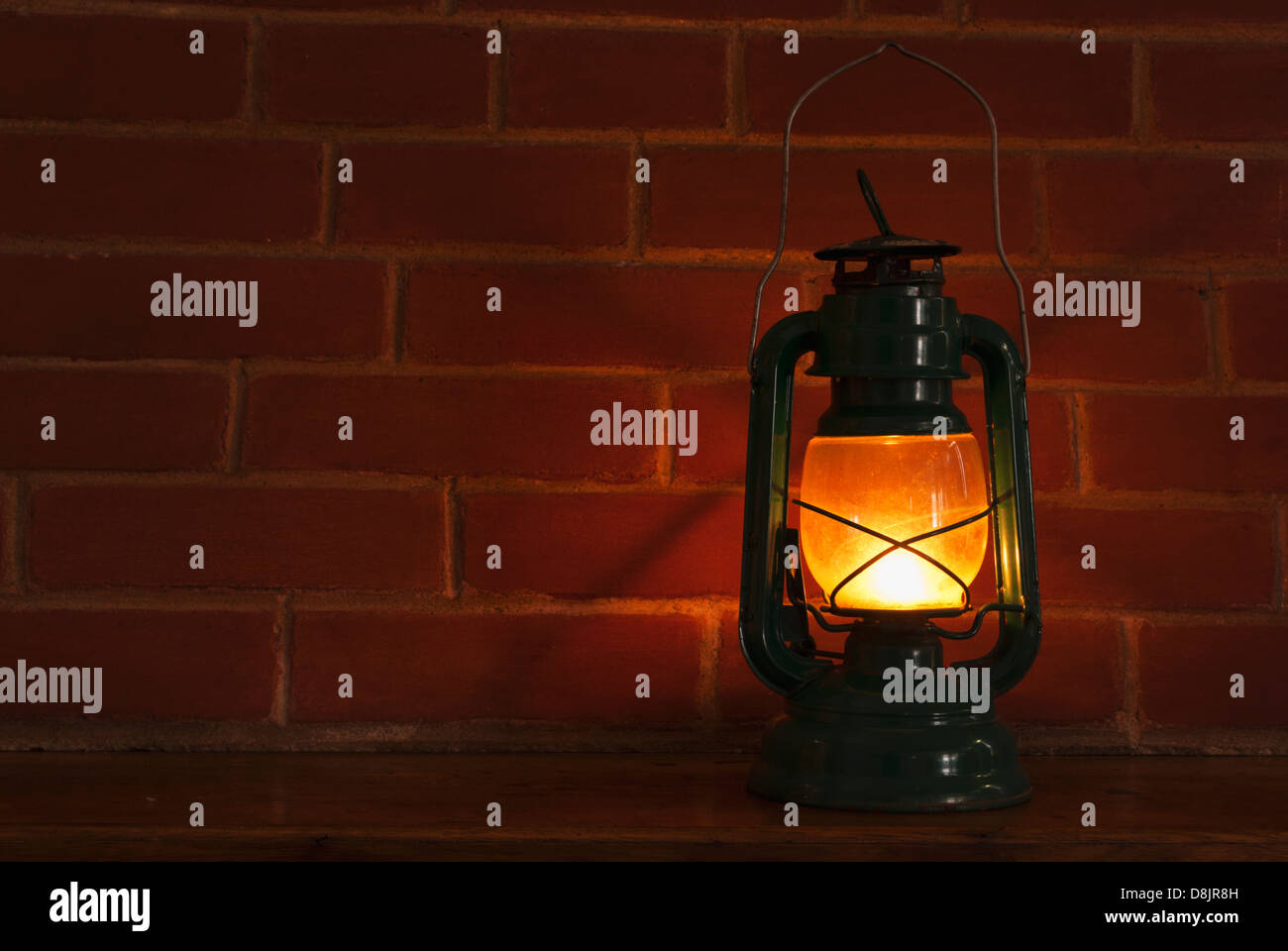 Une lampe à huile style lanterne éclairage à l'avant d'un arrière-plan brickwall. Banque D'Images