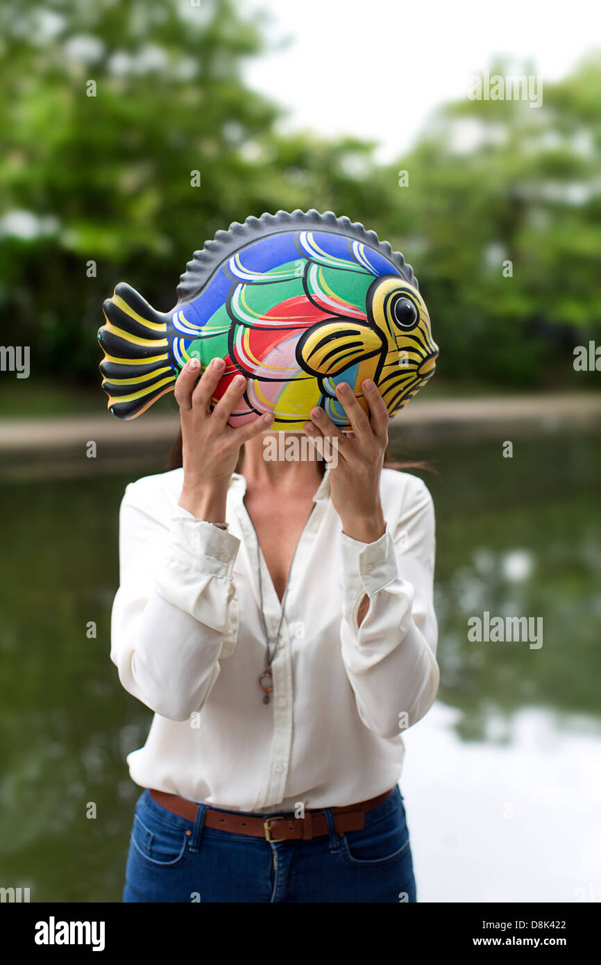 Une fille avec un poisson en céramique Banque D'Images