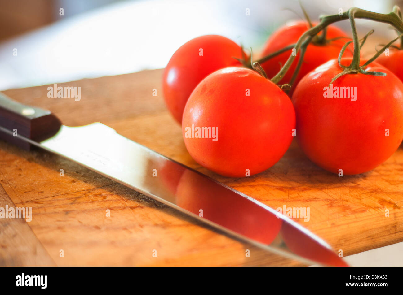 Les tomates sur une planche à découper en tranches et prêt à manger. Banque D'Images