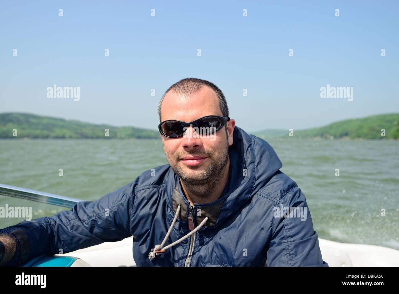 L'homme dans un bateau à moteur à la recherche de l'appareil photo Banque D'Images