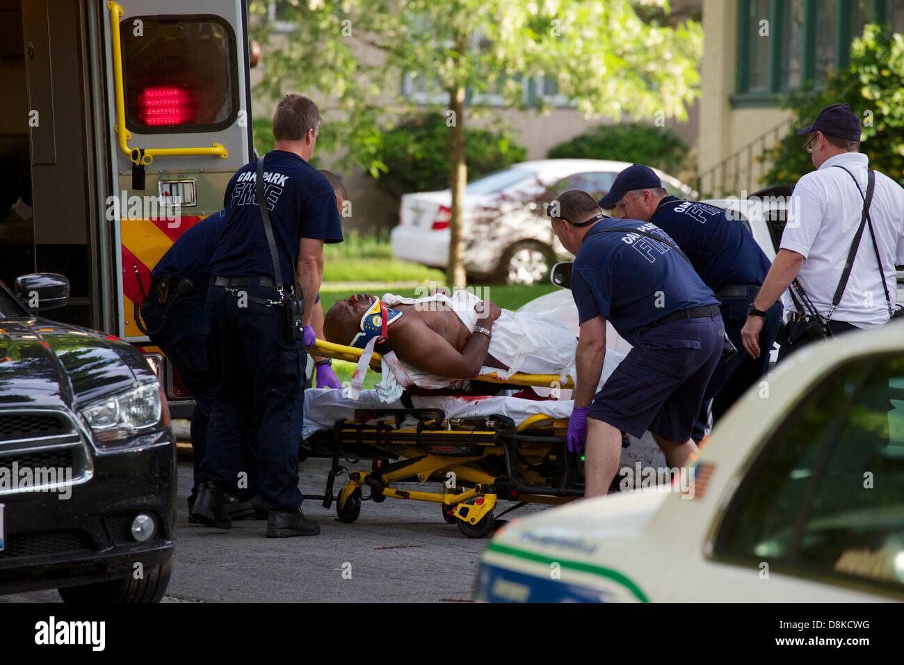 Oak Park, Illinois, USA, 30 mai 2013. Oak Park Fire Department paramédicaux rush une victime vers une ambulance en attente sur le bloc 900 de l'Avenue Taylor. Les détails et l'identité de la victime ou shooter ne sont pas connus à ce jour. L'agresseur est toujours en liberté. Credit : Todd Bannor/Alamy Live News Banque D'Images