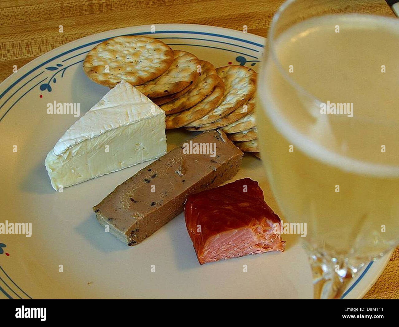 Un plat élégant composé de fromage Brie, pâté de saumon fumé, craquelins et champagne. Cette sélection gastronomique met en valeur des associations de plats luxueux souvent appréciés dans des cadres gastronomiques ou des célébrations spéciales. Banque D'Images