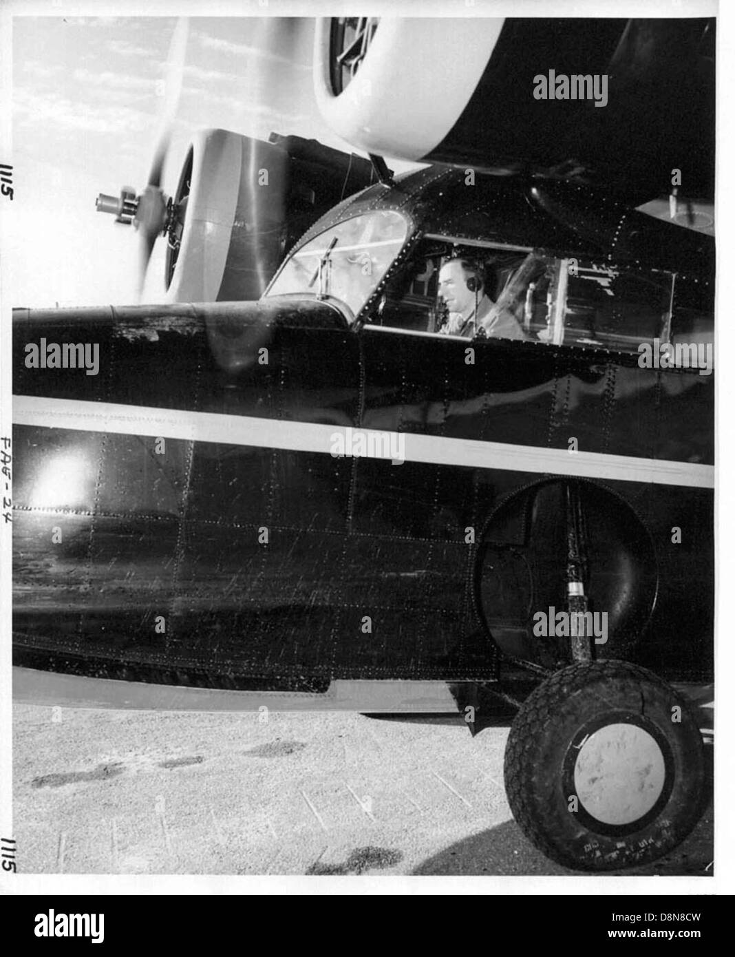 Une photographie vintage d'une personne pilotant un vieil avion. L'image montre l'intérieur du cockpit avec le pilote aux commandes, capturant les premiers jours de l'aviation. Banque D'Images