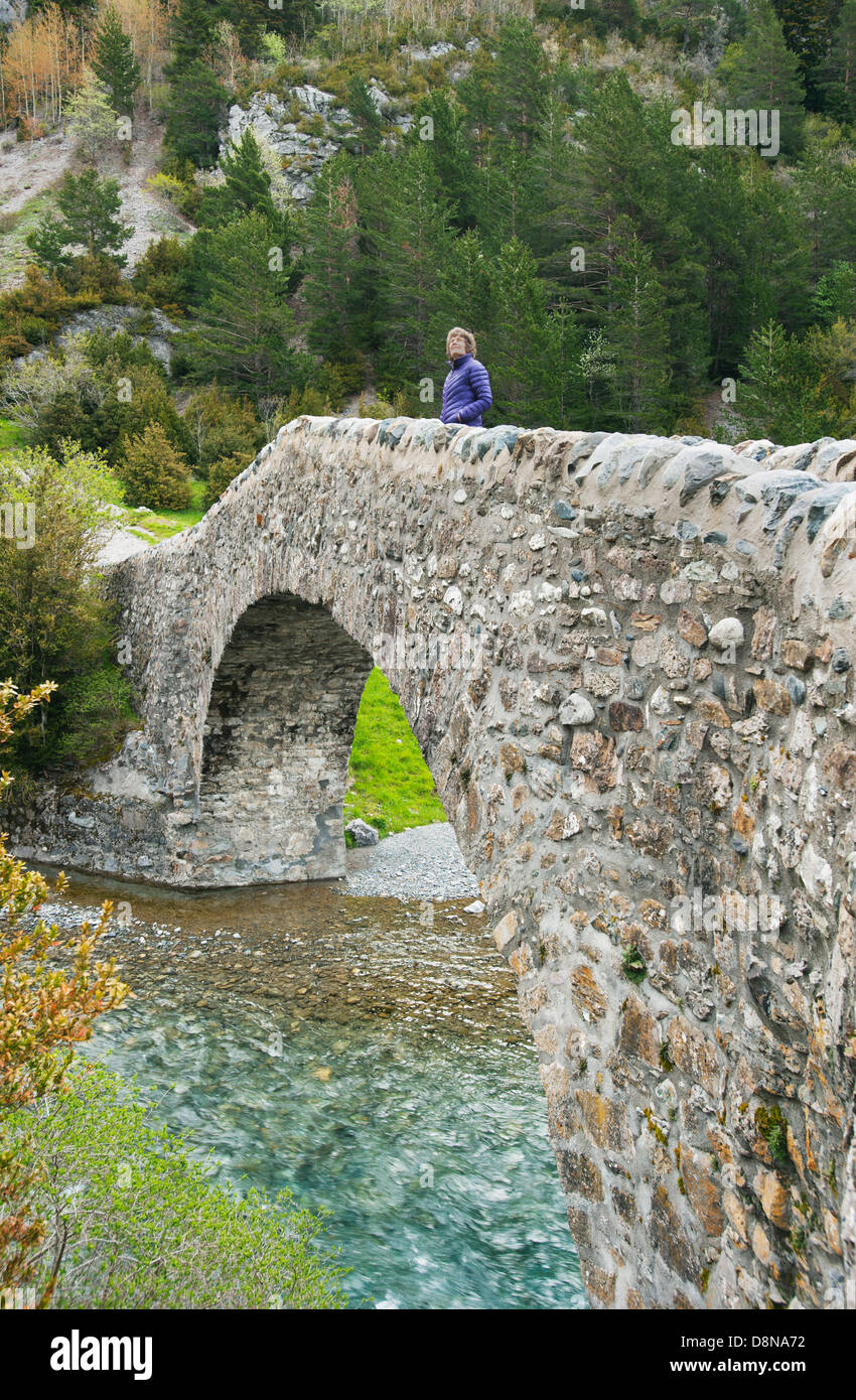Femme sur pont roman, Bujaruelo Vally, La Rivière Ara, Ordesa-Monte Perdido Parc National des Pyrénées, site classé au patrimoine mondial, l'Espagne Banque D'Images