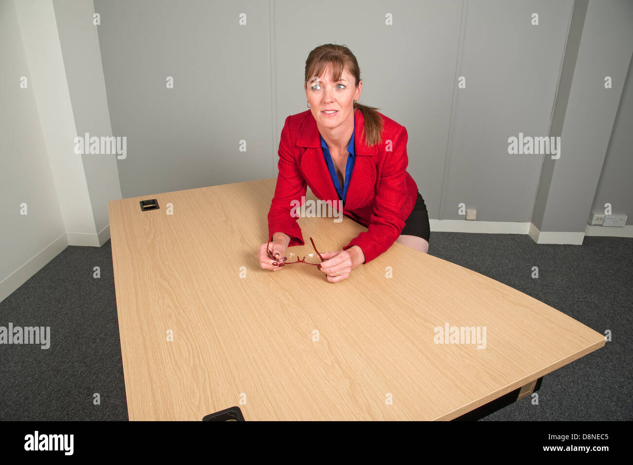 Femme assise à un nouveau bureau dans un bureau vide Banque D'Images