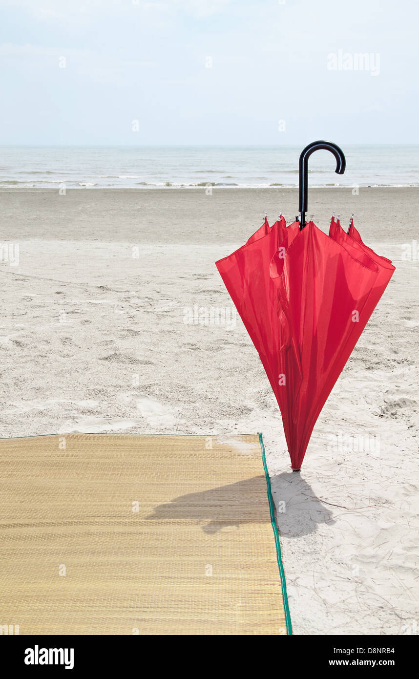 Parapluie rouge et bambou sur la plage Banque D'Images