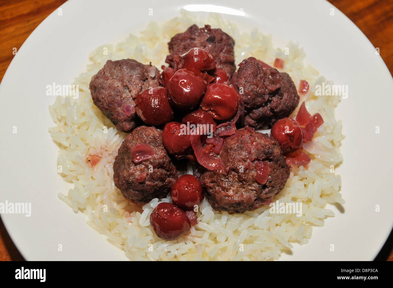 Une assiette de boulettes de viande à la sauce aux cerises sur le riz Banque D'Images