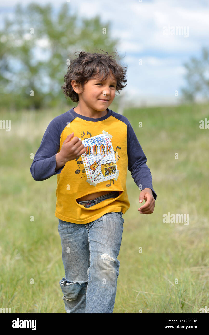 Jeune garçon courir avec une chemise déchirée, Wallowa Valley, Oregon. Banque D'Images