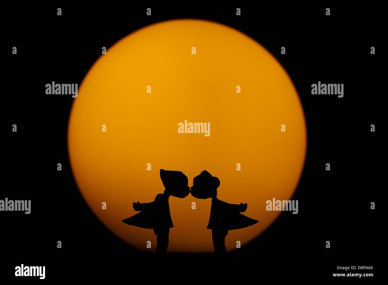 Silhouette d'embrasser des figurines en face de Pleine Lune Banque D'Images