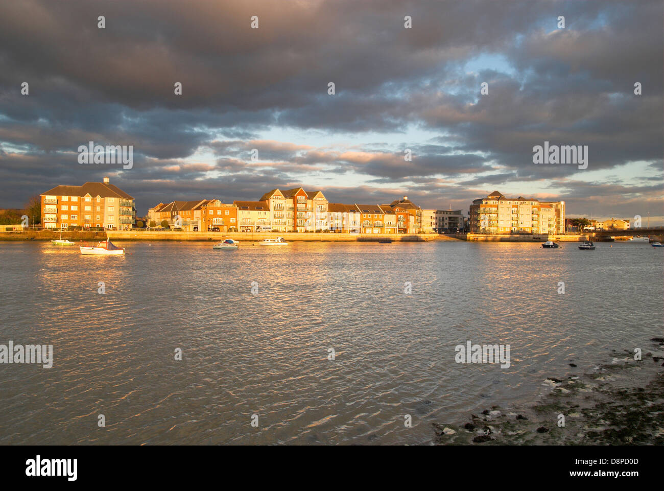 Fin d'après-midi met en lumière un développement de maisons en bord de mer à côté de la rivière Adur dans le West Sussex, Angleterre du Sud. Banque D'Images