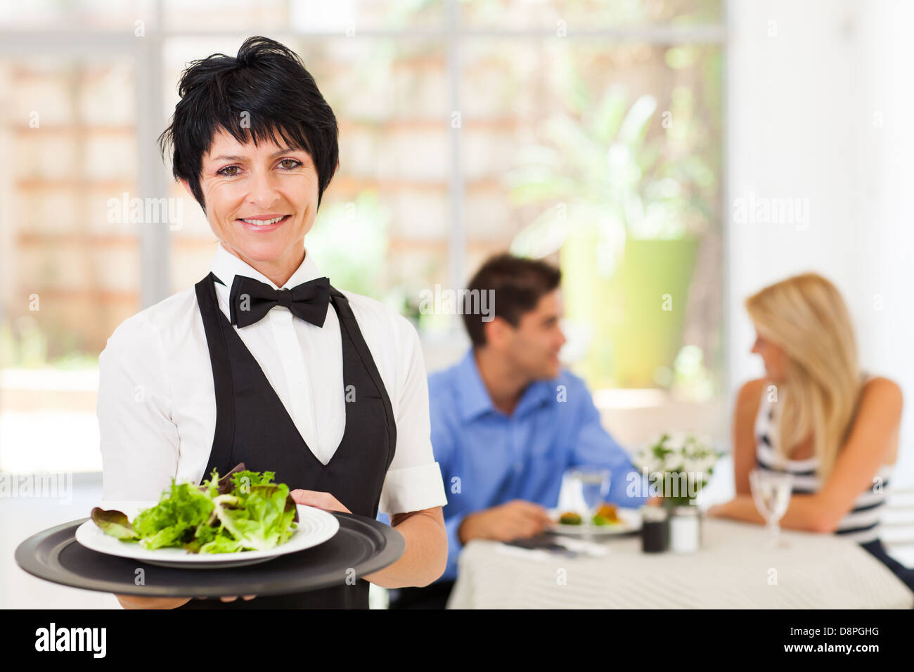 Jolie serveuse d'âge moyen working in restaurant Banque D'Images