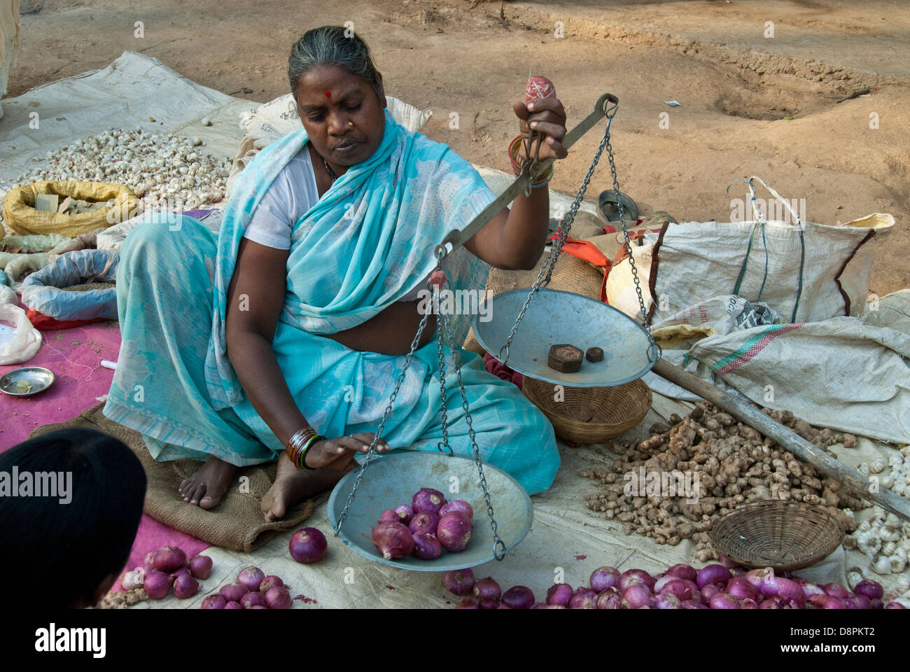 Femme indienne de l'oignons de pesage du vendeur au marché indien au Village de Moka, Madhya Pradesh, Inde Banque D'Images