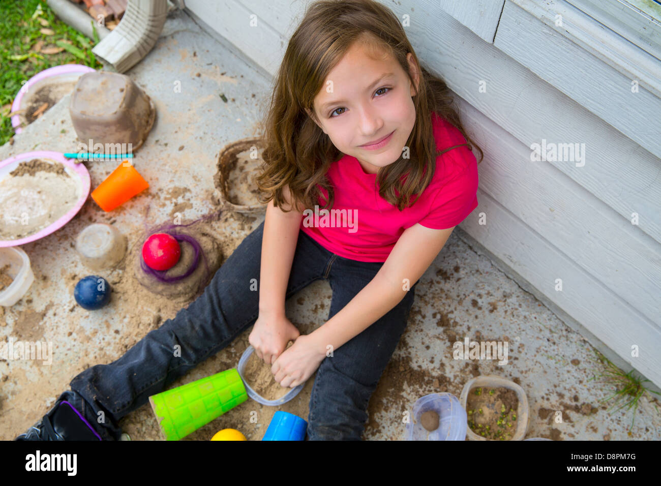 Fille jouant avec de la boue dans un sol malpropre smiling portrait je cherche de high point Banque D'Images