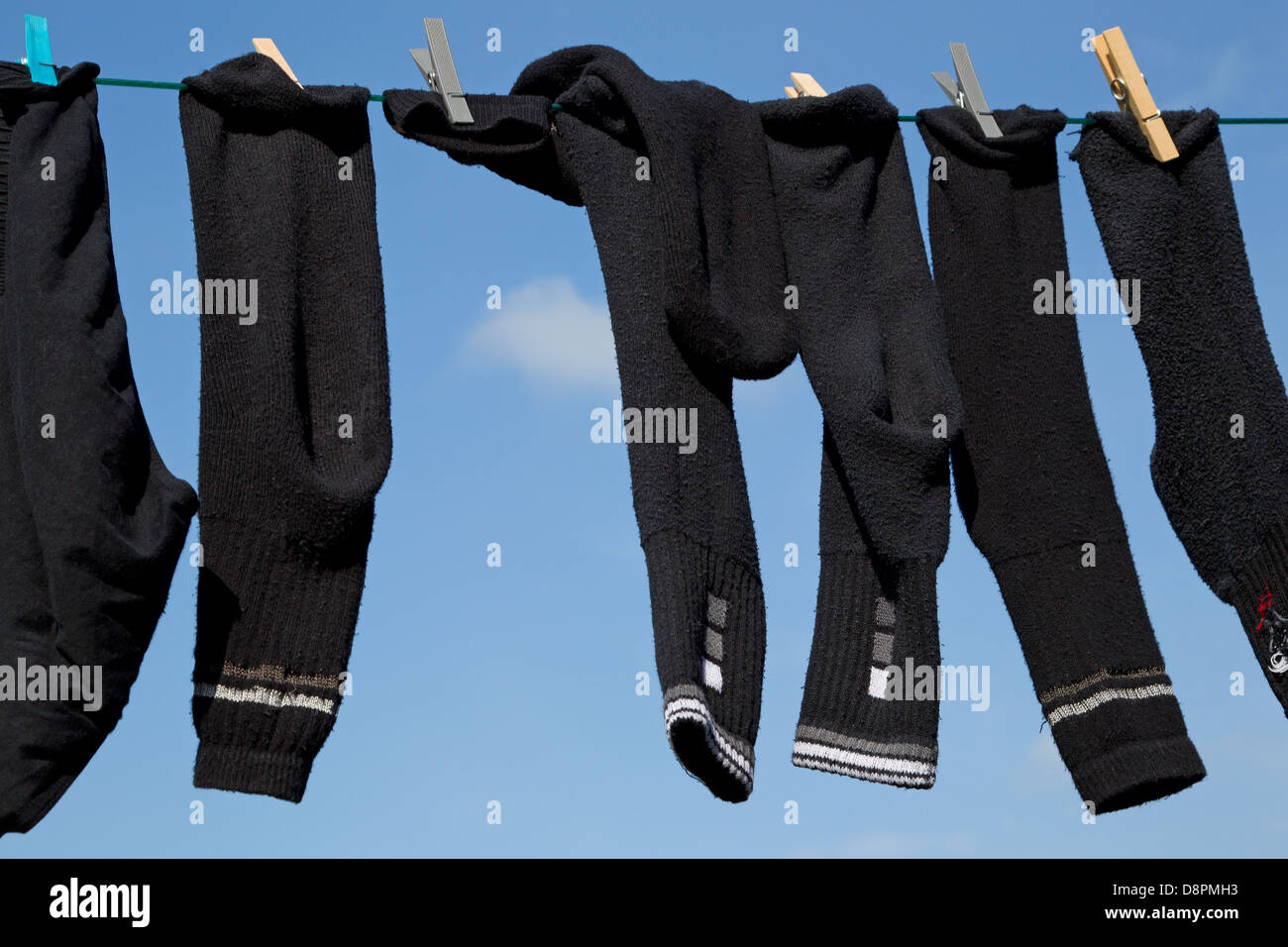 Chaussettes et pantalon arrimé sur un lave-ligne, contre un fond de ciel Banque D'Images
