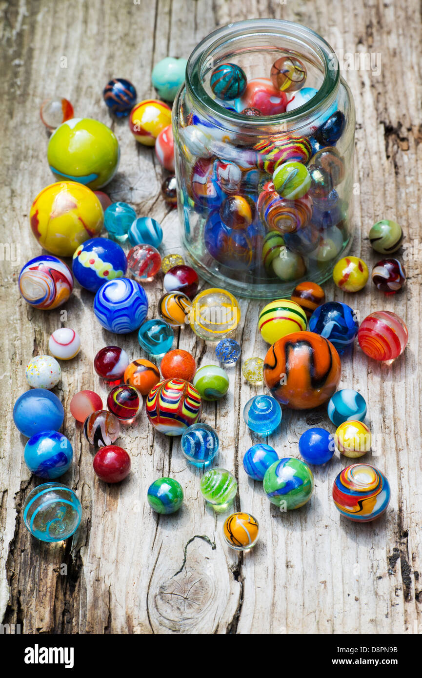 Marbres colorés et bocal en verre sur le vieux bois Banque D'Images
