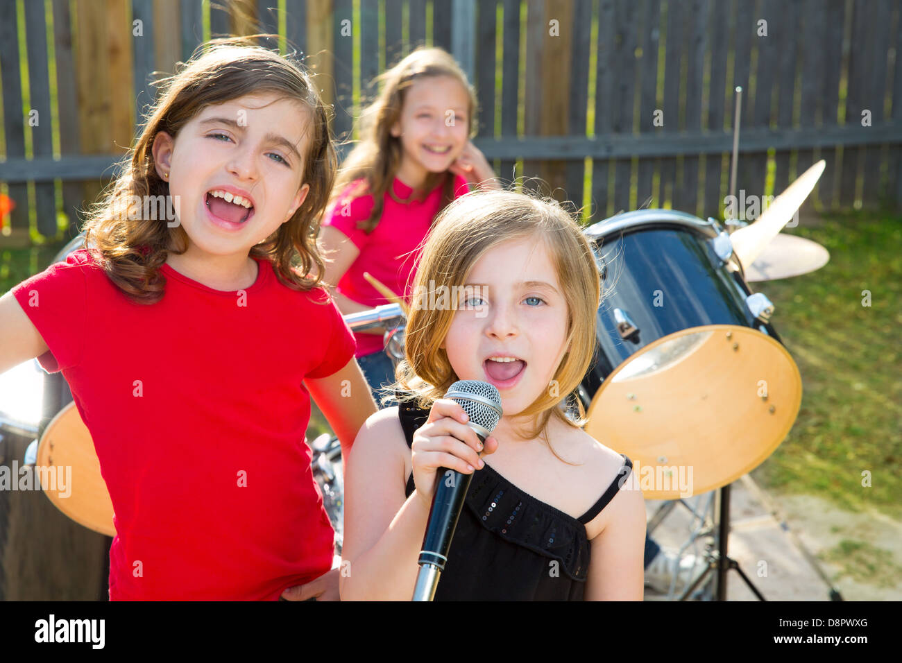 Chanteur pour enfants blonde girl singing jouer live band en concert d'arrière-cour avec des amis Banque D'Images