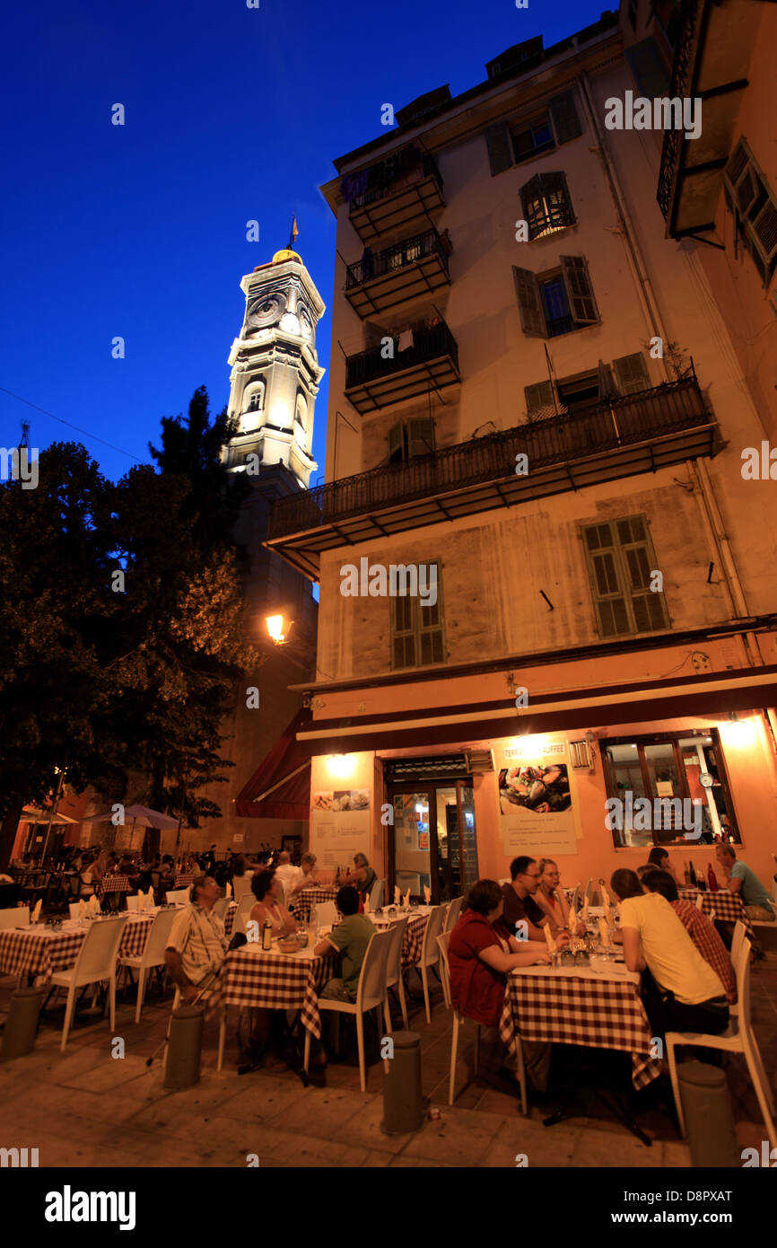 Les personnes ayant à manger en extérieur dans un restaurant de la vieille ville de Nice ville de nuit. Banque D'Images