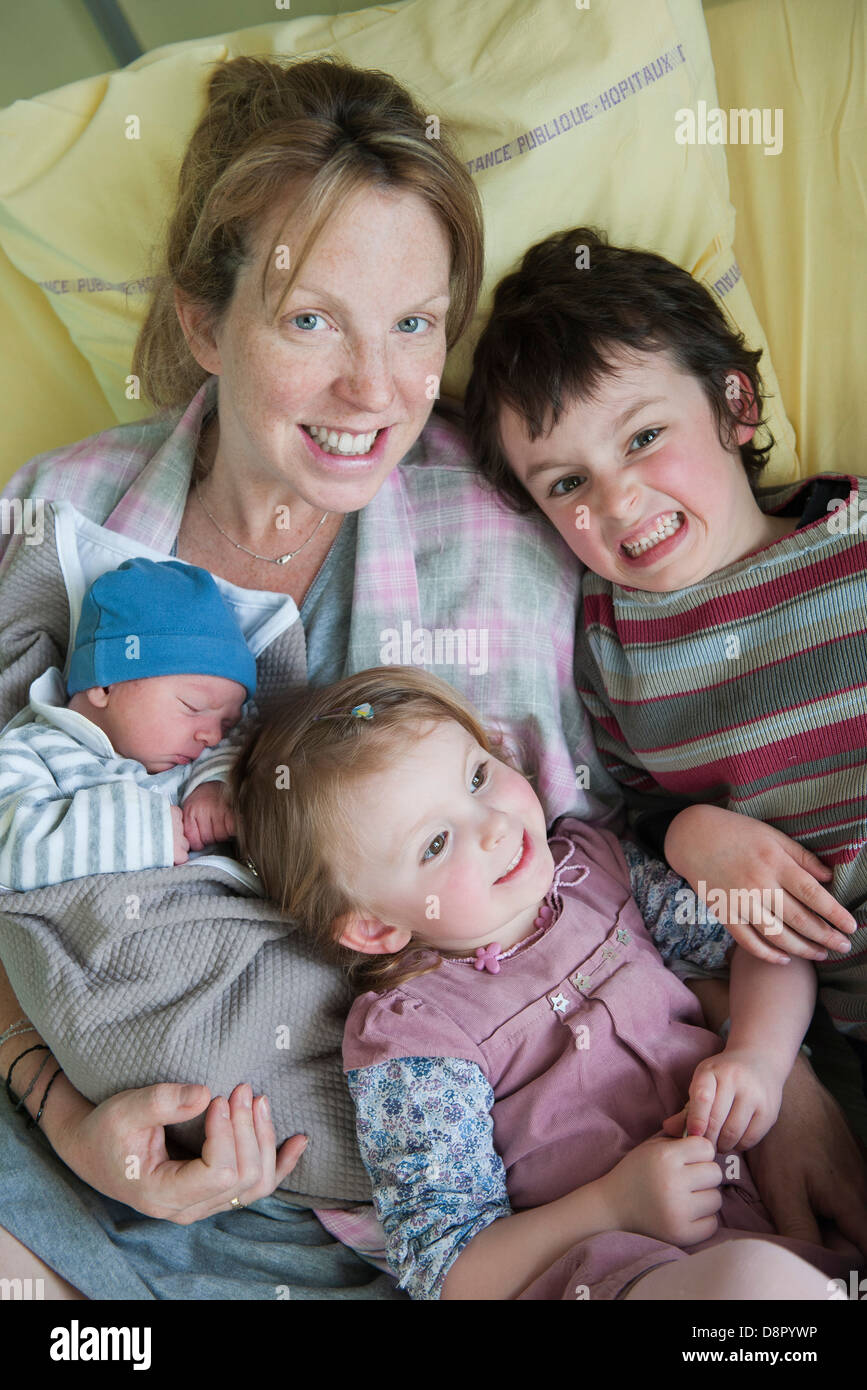 Mère assis sur lit d'hôpital avec des enfants et nouveau-né, portrait Banque D'Images