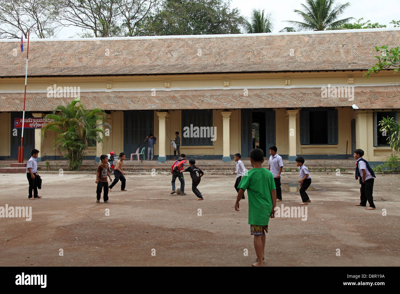 Les enfants de l'école jouer au football à l'école terre, Luang Prabang, Laos Banque D'Images