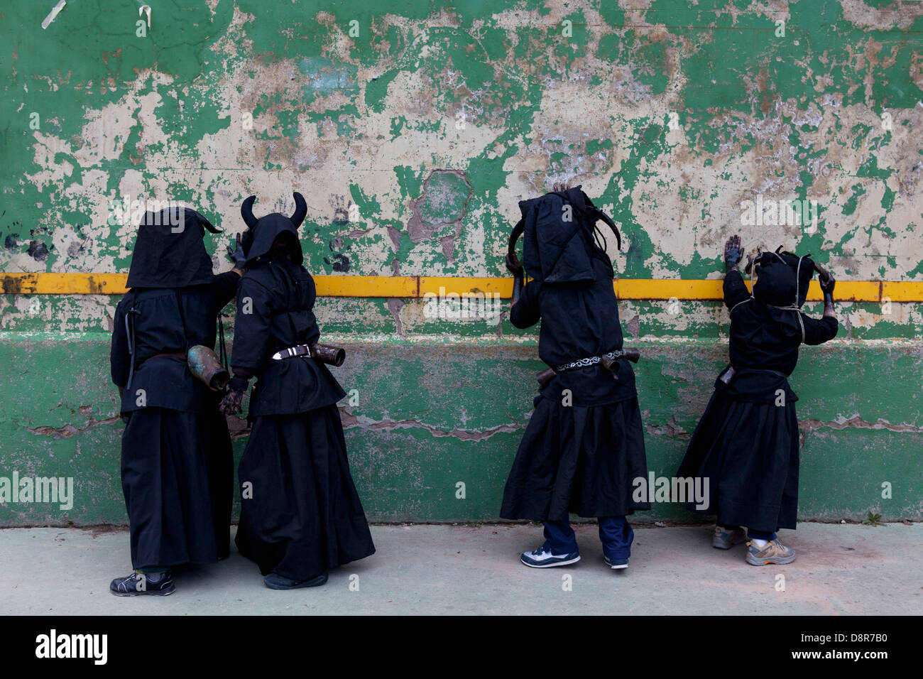 Carnaval. Les Diables de Luzon. Un groupe d'enfants habillés comme des démons de marquer leurs mains noires sur un mur Banque D'Images
