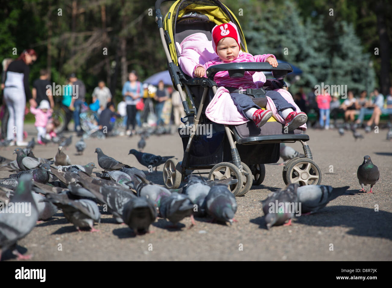 Enfant fille jouant avec des colombes dans la ville street Banque D'Images